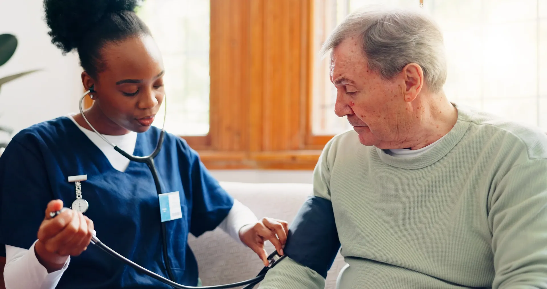 Nurse checking blood pressure of an elderly patient at home